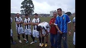 Rodinha de jogadores pegando no pau durante treino.