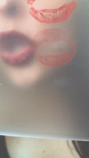 Dark red lipstick. Kiss marks on plexiglass.
