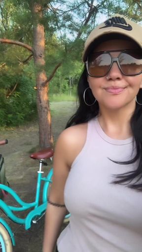 Woman in sunglasses standing next to bicycle