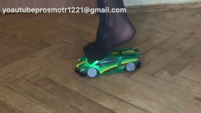 Nastya, wearing black tights, steps on a toy car with all her weight and crushes it. Footish and crush fetish