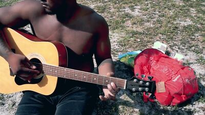 Amateur African chap is playing a guitar in front of the cam