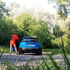 I clean the windows of my car on the side of the road in a minidress with an anal plug