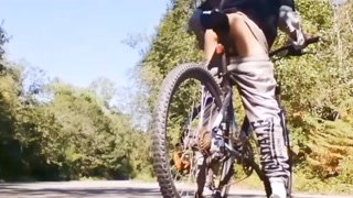 Very daring and very handsome boy plays with his bicycle in public