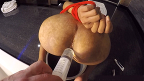 Pissing on big ass of an Asian ladyboy and filling it to squirt