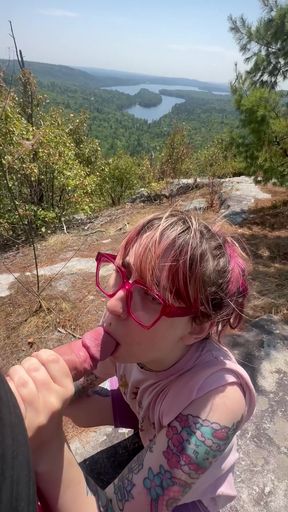 Girl with glasses sitting in front of a lake