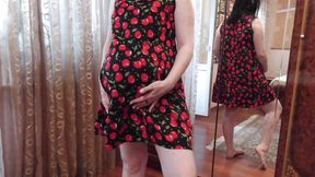 Beautiful pregnant Anna tries on a dress near the mirror