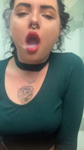 Slim curly haired brunette playfully smokes vape