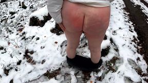 Spanking her naked breasts and pussy in the snow