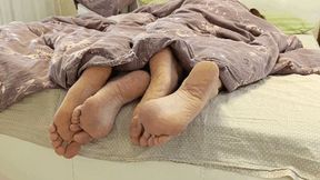 Flirting legs under the blanket