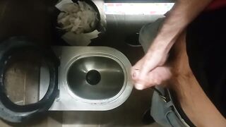 A thin unshaved man promptly strokes off in an airport restroom