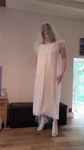Sissy wearing a wedding dress caged and plugged