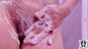 Busty brunette massages and soaps her massive tits and glistening slit