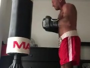 working the bag in red boxing trunks