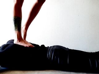 Trampling. Dominatrix Nika walks on the back of her slave with bare feet