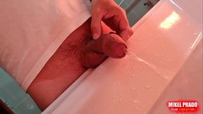 Young guy pissing in the washbasin