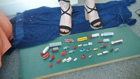 Giantess Jayne vs 30 tiny tiny wiking cars, trucks & bus in chunky sandals toy car crush high left view