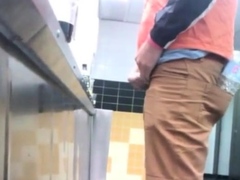 Guys in the urinals taking leak.