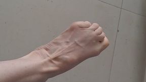 Foot dangle, stretch, and dry sole over dirty floor.