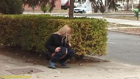 Beauty pissing on street behind bushes
