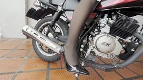 Dalilah struggles to start the motorcycle while wearing high heels