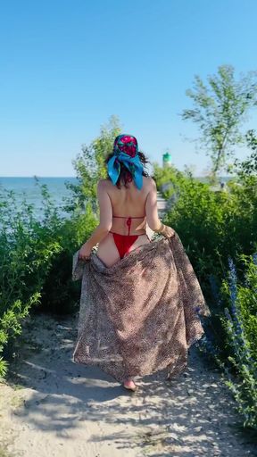 MILF in a bikini shows off her ass on the beach