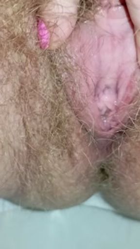 Detailed close-up footage of a hairy pussy girl urinating from her pee hole and farting loudly