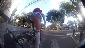 Flaquita culona con minifalda en bicicleta, mostrando las bragas y el culo a desconocido