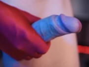 A man in a white shirt masturbates his penis in red gloves