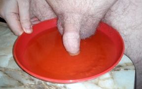 John is peeing on a plate with the cock in the pee