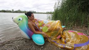Jade blows two inflatables with her mouth on the lake