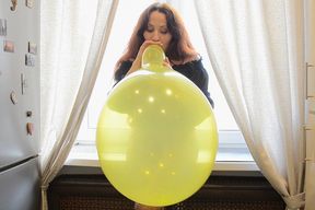 Nathalie Blows To Pop Yellow Balloon