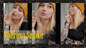 Theresa Smoke calmly smokes a cigarette in the rain during a relaxed outdoor close-up
