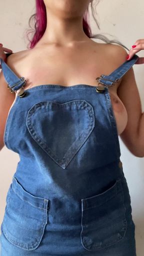 Cute farm girl in overalls takes off her shirt