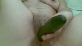 Masturbating with a long green cucumber on home vid