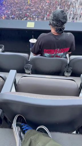 Professional-looking man sits alone in bleachers at a concert
