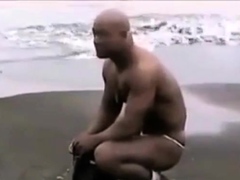 Asian bodybuilder barely covered at the beach