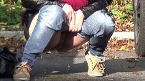 Nice shaped amateur brunette is just pissing on the parking lot