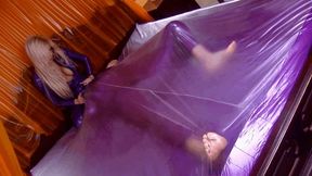 Latex Mistress And The Slave In Purple Plastic Vacuum Packed Bed