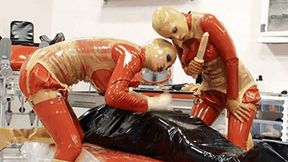 Two latex goddess and the slave catheterised in inflatable rubber - Part 2 of 2 - The catheter and the piss