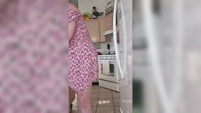 Older woman's lustful encounter with oversized sex toy in kitchen area.