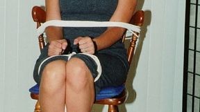Her wrists handcuffed in front, dark-haired struggler Becky Rico sits roped to a chair and tape-gagged!