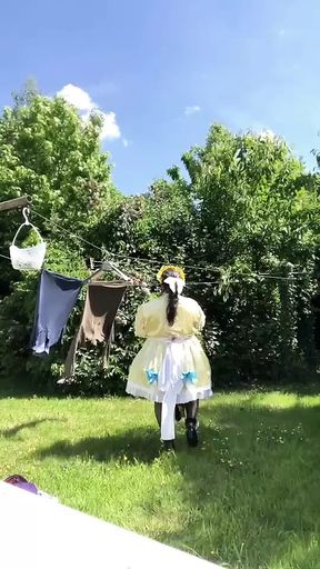 In an outfit with a yellow and blue maid dress to hang the laundry.