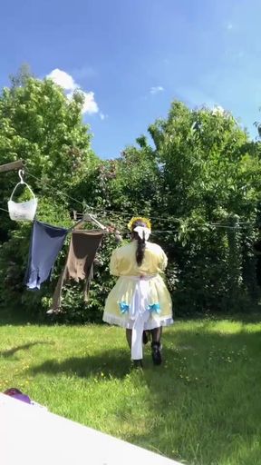 In an outfit with a yellow and blue maid dress to hang the laundry.