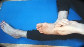 The fellow rubs his soles with lubricant