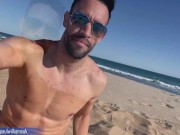 Fitness young man gets naked on Barcelona public beach after gym workout