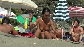Oily brunette chick takes sunbath on nude beach completely naked