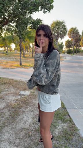 Woman in camo jacket standing outdoors