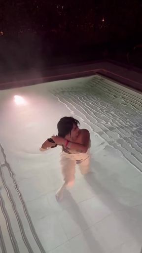 Romanian babe with big tits enjoys a dip in the pool wearing her bikini.