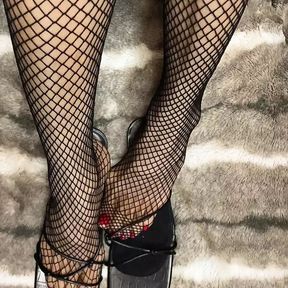 Fishnet in open toe shoes with red nail polish