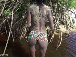 Slender tribe gal with a body full of mud exposed outdoor